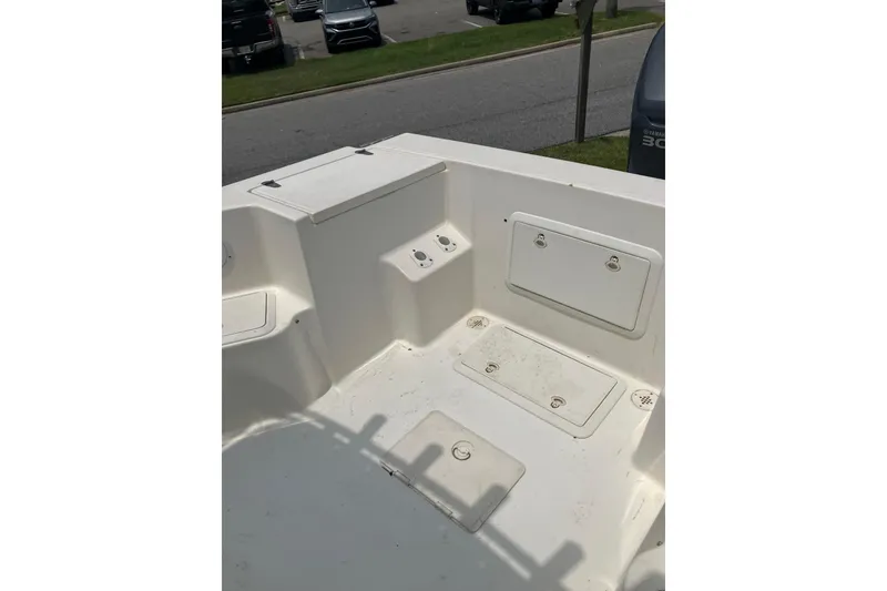 Slide: The Image of 2003 Seapro 239 boat interior with storage compartments and clean white deck. - 11