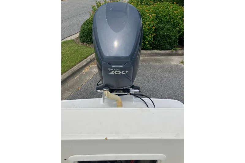 Slide: The Image of Outboard motor on a 2003 Seapro 239 boat, parked near greenery. - 17