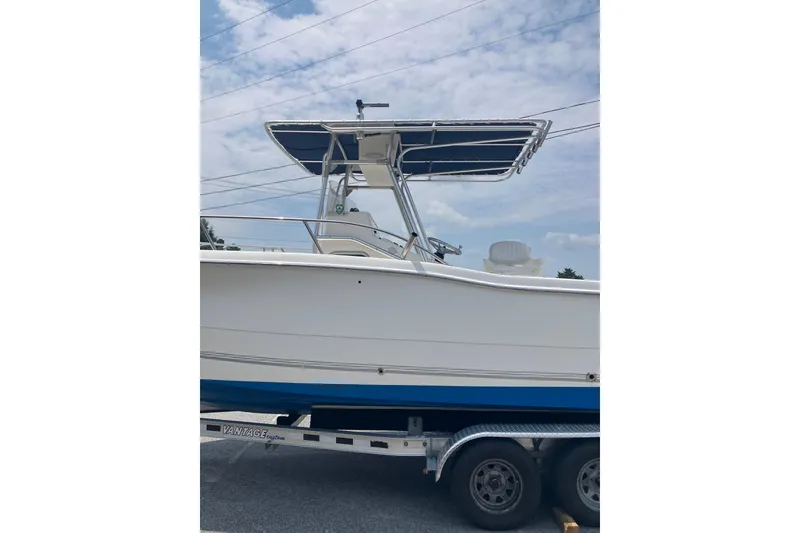 Slide: The Image of 2003 Seapro 239 boat on trailer, featuring a blue and white hull with a T-top. - 3