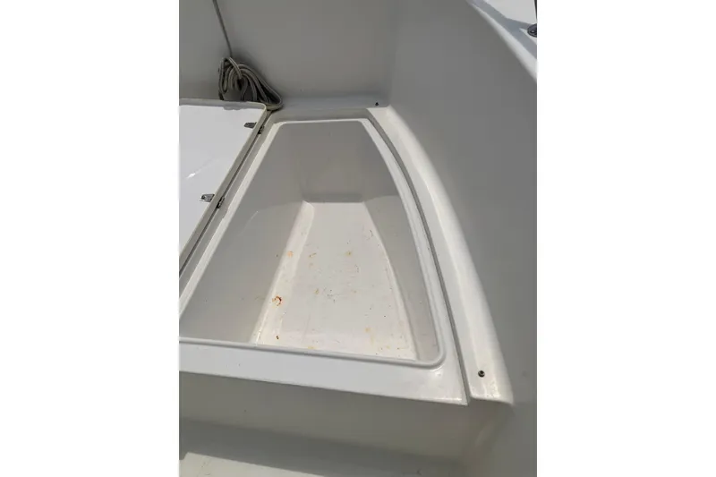 Slide: The Image of Storage compartment of a 2003 Seapro 239 boat, featuring a clean, white interior. - 14