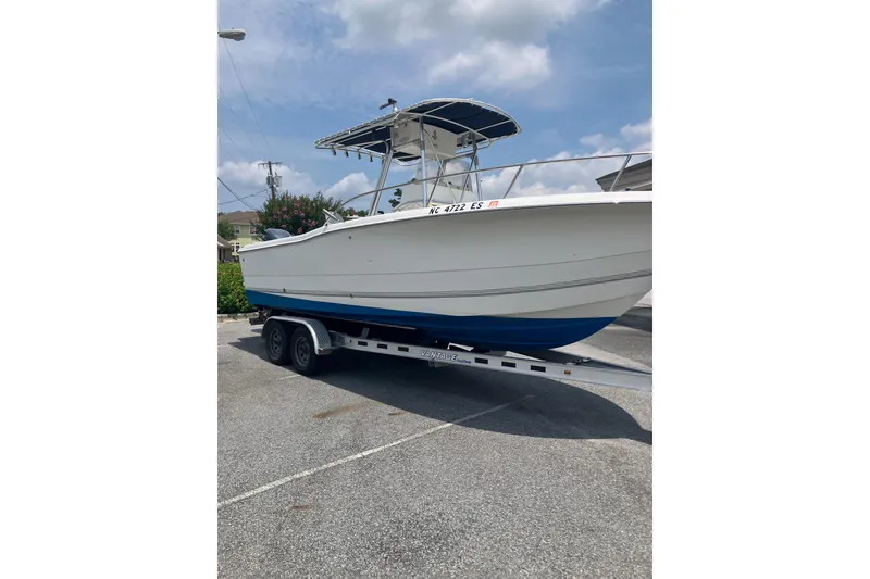 Slide: The Image of 2003 Seapro 239 boat on trailer, parked outdoors under a cloudy sky. - 22