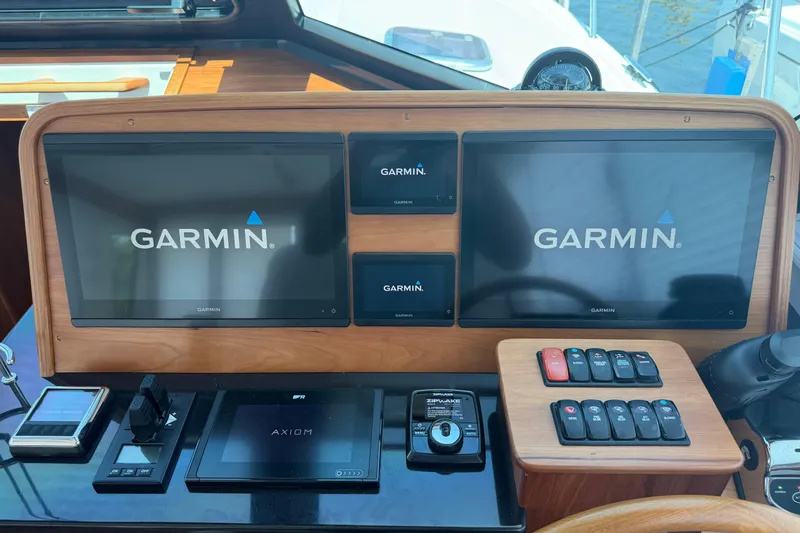 Slide: The Image of 2024 Back Cove 372 helm with Garmin navigation displays and control panel. - 39