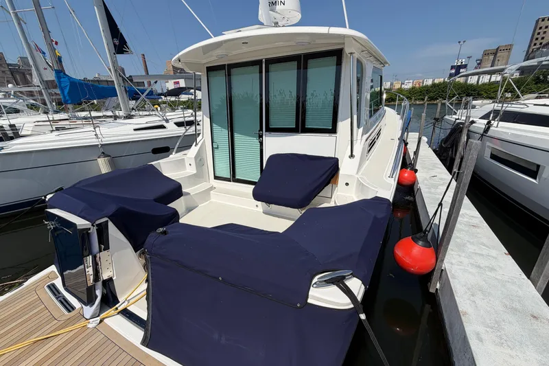 Slide: The Image of 2024 Back Cove 372 yacht docked, featuring a spacious deck with navy blue covers. - 70