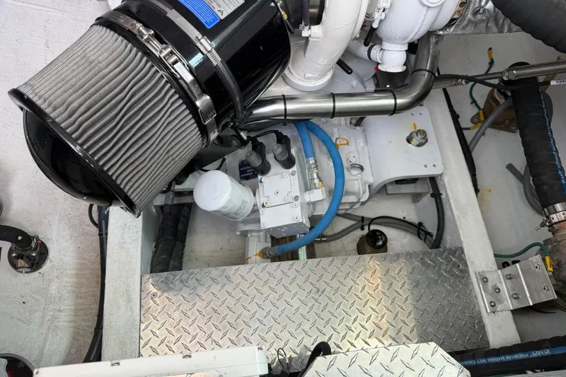 Slide: The Image of Engine compartment of 2024 Back Cove 372 boat, showcasing mechanical components and piping. - 84