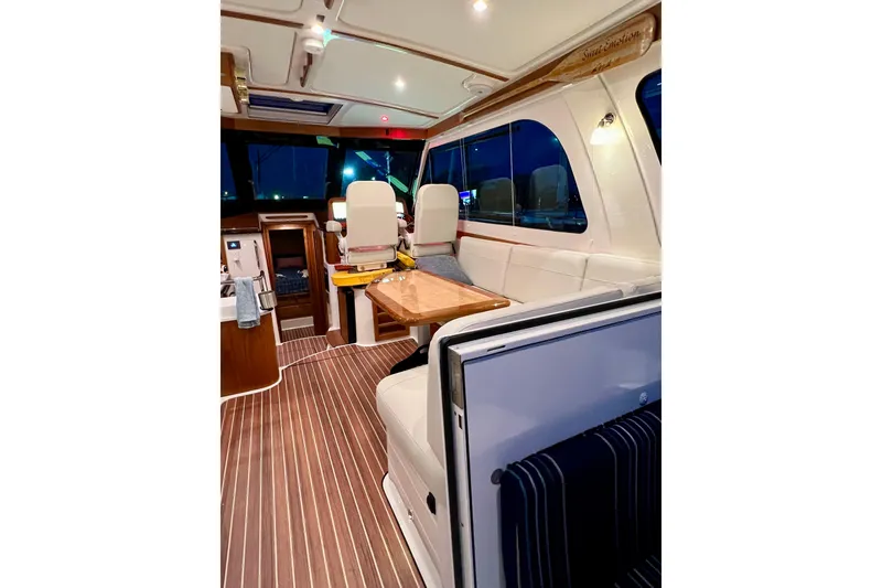 Slide: The Image of Interior of 2024 Back Cove 372 yacht, featuring elegant seating and wooden flooring. - 22