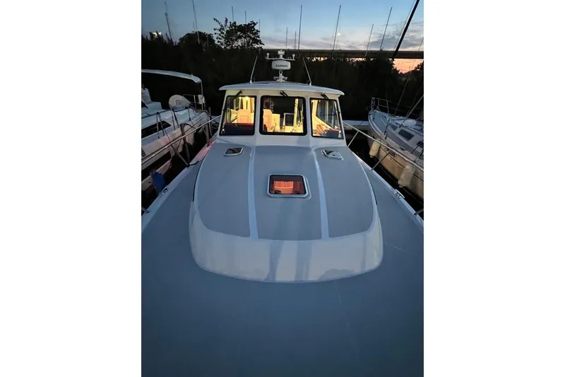 Slide: The Image of 2024 Back Cove 372 boat docked at sunset, showcasing sleek design and spacious deck. - 20