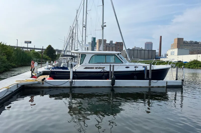 Slide: The Image of 2024 Back Cove 372 yacht docked at marina with urban skyline backdrop. - 12