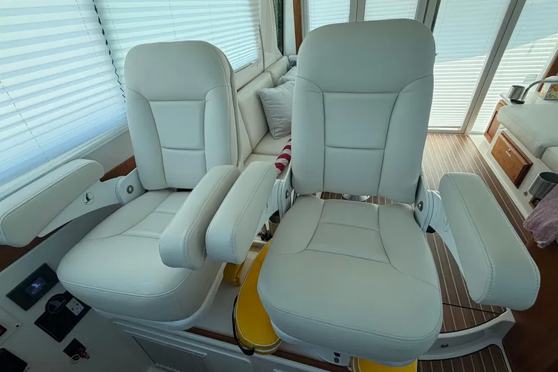 Slide: The Image of Luxury seating in 2024 Back Cove 372 yacht interior, featuring plush white captain chairs. - 60