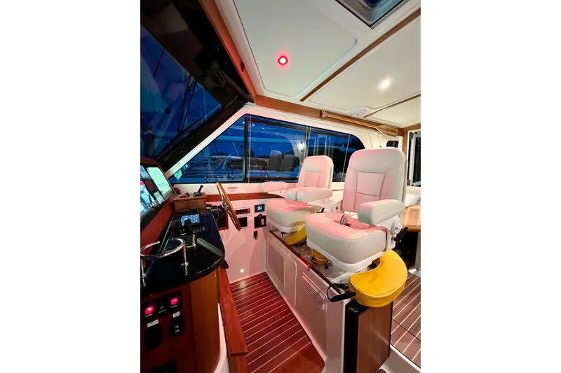 Slide: The Image of 2024 Back Cove 372 yacht interior with helm seats and navigation controls. - 24