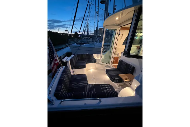 Slide: The Image of 2024 Back Cove 372 yacht with illuminated seating area at dusk. - 19