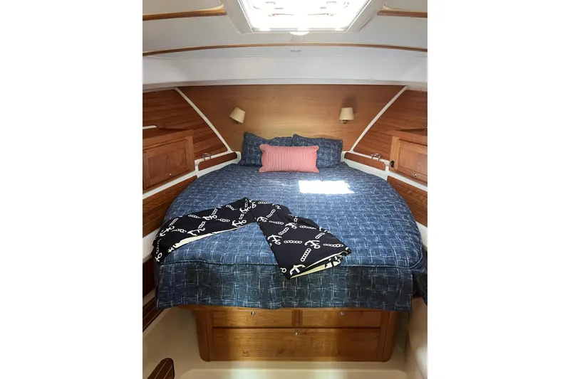 Slide: The Image of 2024 Back Cove 372 cabin interior with cozy bed, wooden accents, and nautical-themed decor. - 23
