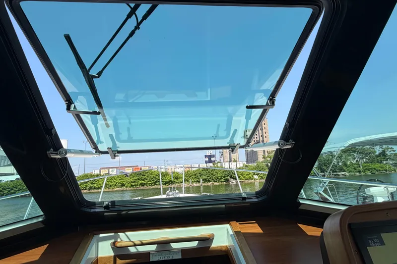 Slide: The Image of Interior view of 2024 Back Cove 372 yacht with open sunroof and scenic waterway. - 62