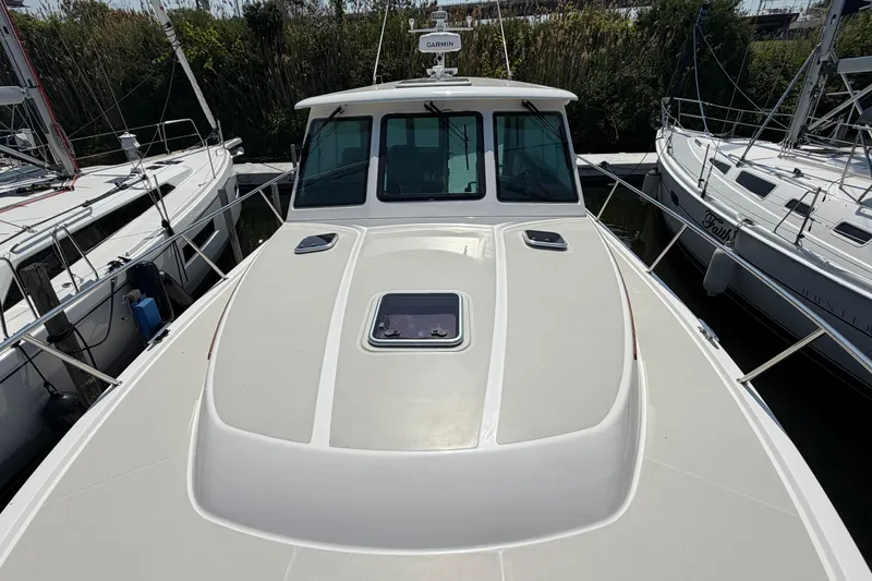 Slide: The Image of 2024 Back Cove 372 boat docked, showcasing sleek design and spacious deck. - 68