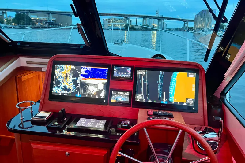 Slide: The Image of 2024 Back Cove 372 yacht helm with advanced navigation displays and waterfront view. - 11