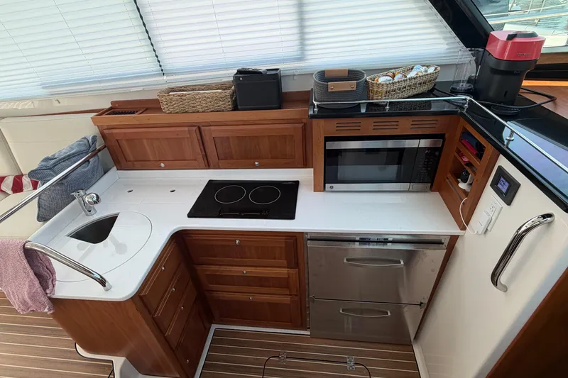 Slide: The Image of Modern kitchen in 2024 Back Cove 372 yacht with stove, microwave, and wooden cabinetry. - 54