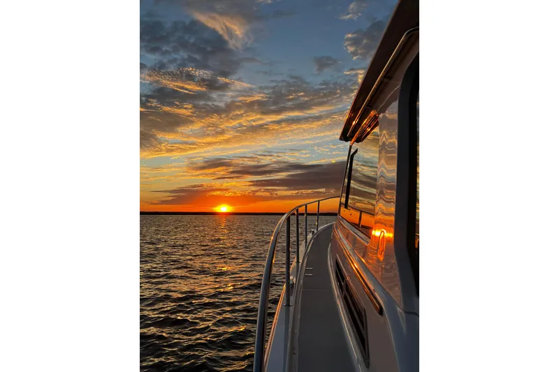Slide: The Image of Back Cove 372 yacht at sunset, 2024 model, reflecting vibrant sky over calm waters. - 29