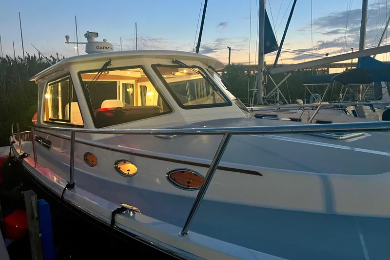 Slide: The Image of 2024 Back Cove 372 boat docked at sunset with illuminated cabin. - 18