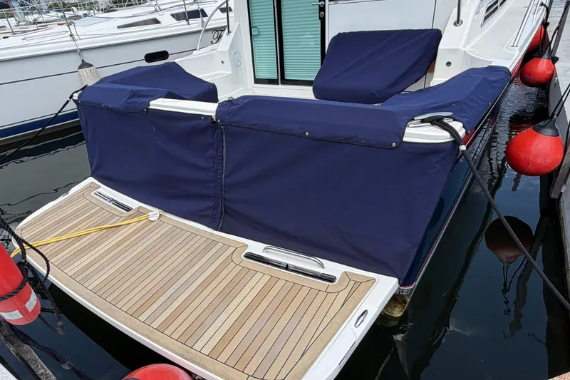 Slide: The Image of 2024 Back Cove 372 yacht with blue cover and wooden deck at marina. - 81
