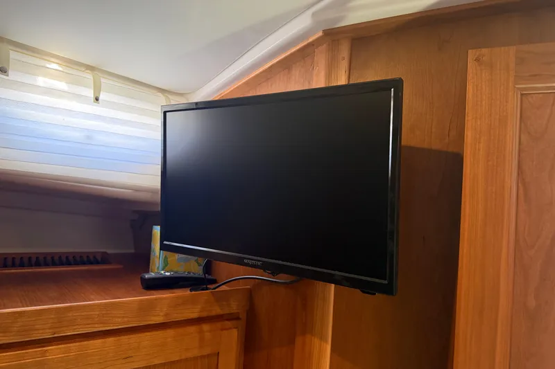 Slide: The Image of Flat-screen TV mounted in 2024 Back Cove 372 yacht interior with wooden paneling. - 32