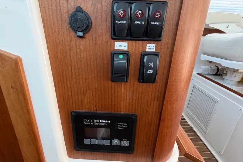 Slide: The Image of Control panel of 2024 Back Cove 372 boat featuring Cummins Onan marine generator. - 61