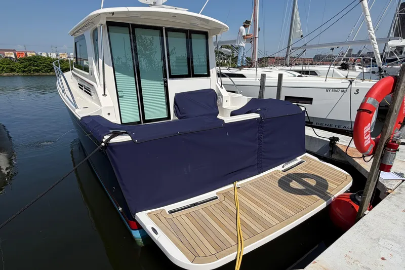 Slide: The Image of 2024 Back Cove 372 yacht docked, featuring a covered deck and modern design. - 77