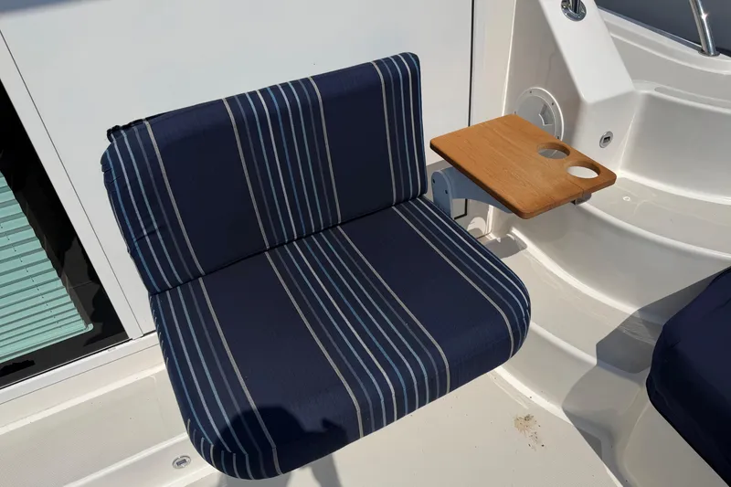 Slide: The Image of Blue striped seat with wooden cup holder on 2024 Back Cove 372 boat. - 72