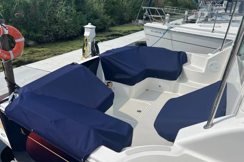 Slide: The Image of 2024 Back Cove 372 boat with blue-covered seating at a dock. - 15