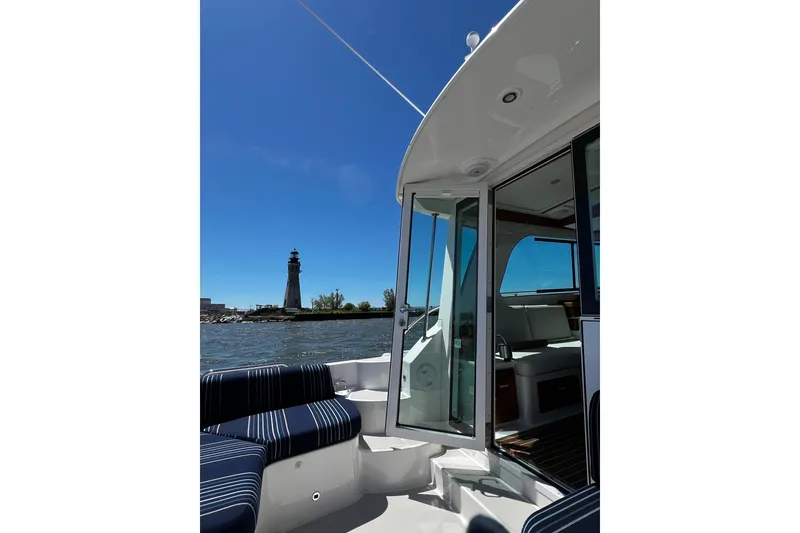 Slide: The Image of 2024 Back Cove 372 boat interior with lighthouse view on a sunny day. - 7