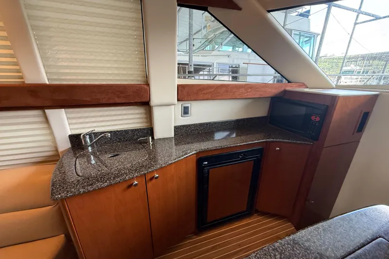 Slide: The Image of Luxurious 2006 Meridian 341 Sedan yacht interior with kitchenette, featuring sink, microwave, and mini-fridge. - 7