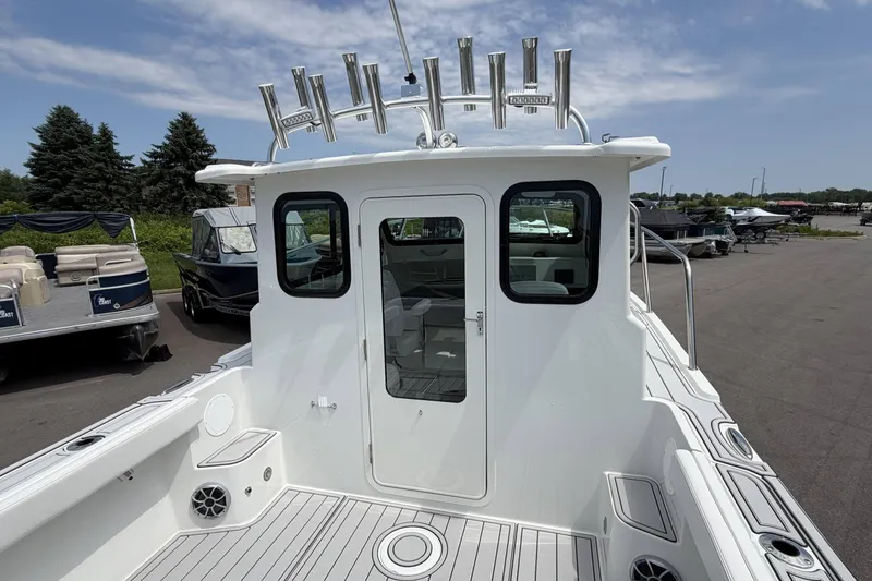 Slide: The Image of Parker 227 Explorer 2027 boat with rod holders, docked under a clear sky. - 9