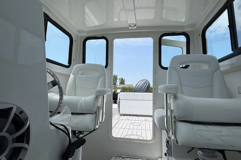 Slide: The Image of Interior of a 2027 Parker 227 Explorer boat with white seating and steering wheel. - 19