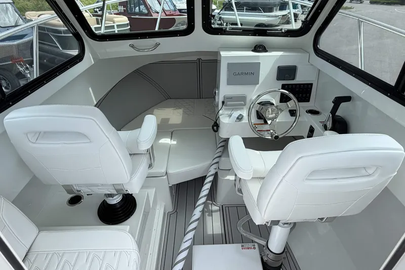 Slide: The Image of Interior of 2027 Parker 227 Explorer boat with white seating and Garmin navigation system. - 10