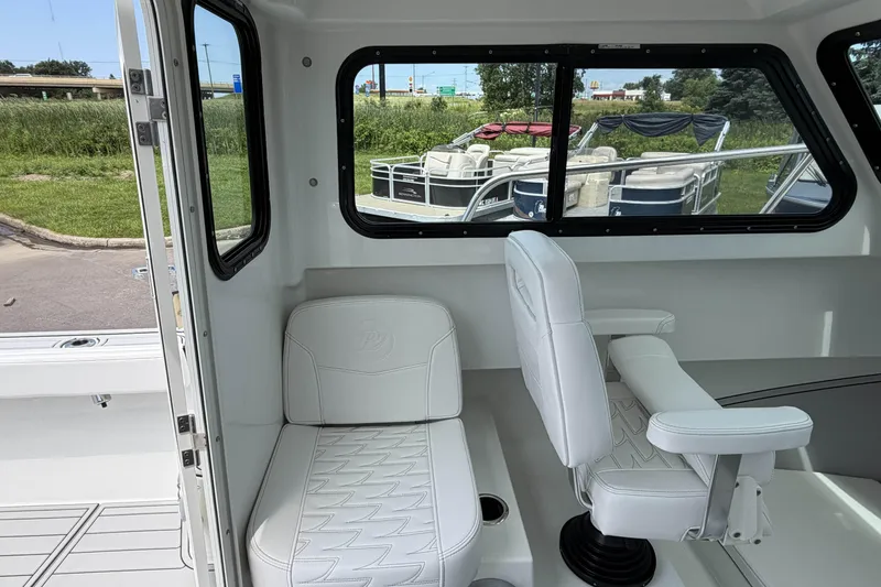 Slide: The Image of Interior of a 2027 Parker 227 Explorer boat with white seating and windows. - 12
