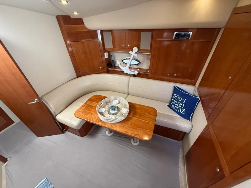 Slide: The Image of Interior of a 2004 Cruisers Yachts 400 Express with elegant wood finish and cozy seating area. - 13