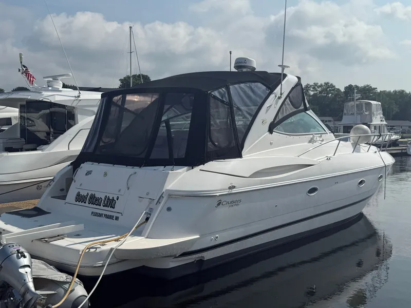 The Image of A 2004 Cruisers Yachts 400 Express is docked in the water, surrounded by other boats. - 0