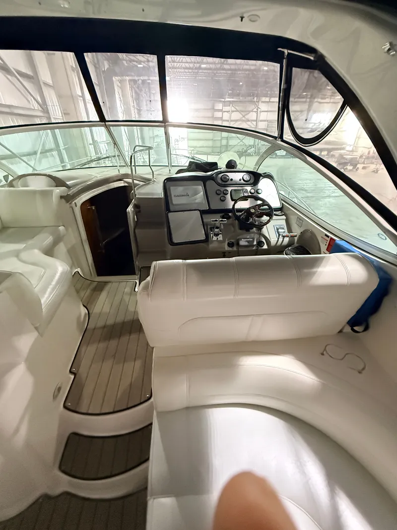 Slide: The Image of Interior of a 2004 Cruisers Yachts 400 Express with white upholstery and helm station. - 11