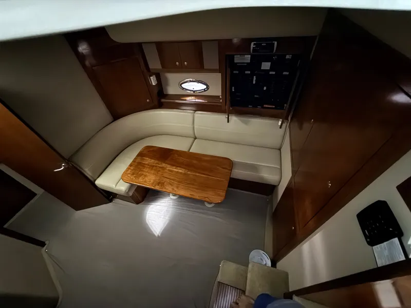 Slide: The Image of Interior of a 2004 Cruisers Yachts 400 Express with leather seating and wooden table. - 21