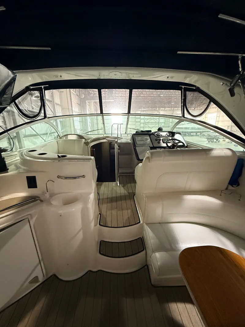 Slide: The Image of Interior of a 2004 Cruisers Yachts 400 Express with white seating and wood accents. - 10