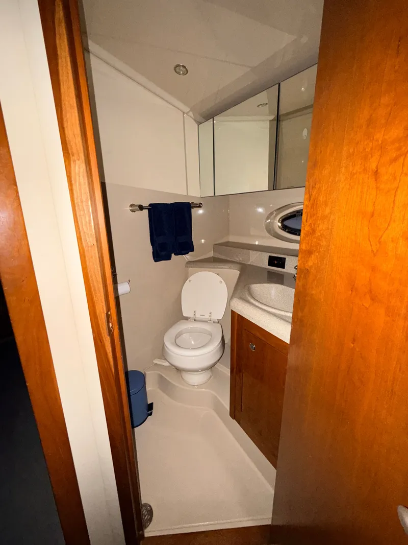 Slide: The Image of The image shows a yacht bathroom with a toilet, sink, and wooden cabinets. - 23