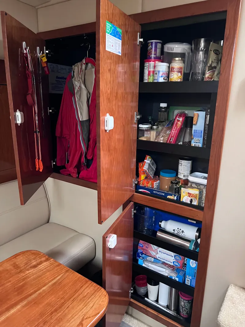 Slide: The Image of Interior view of a 2004 Cruisers Yachts 400 Express with cabinets full of supplies. - 18