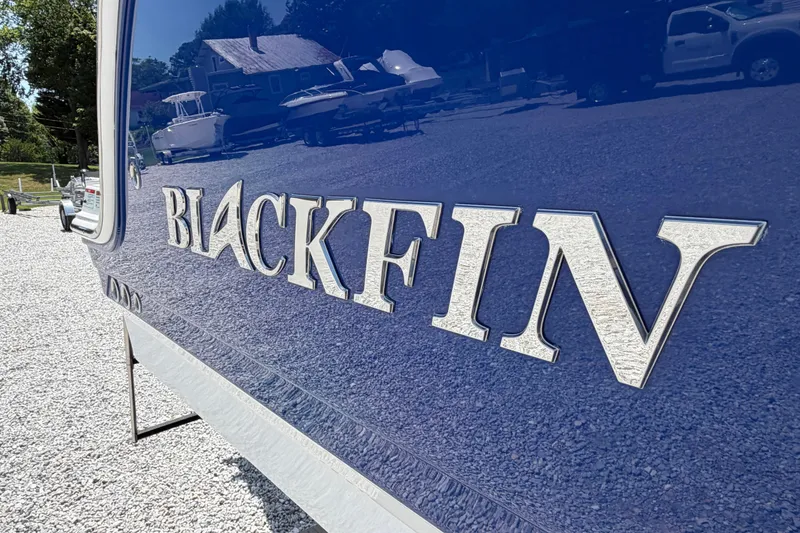 Slide: The Image of 2020 Blackfin 242 DC boat with reflective lettering on a sunny day. - 9
