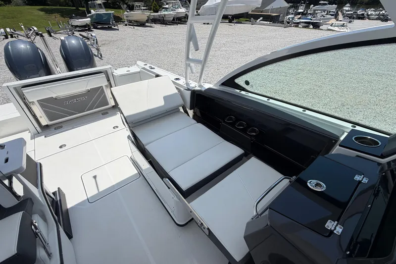 Slide: The Image of 2020 Blackfin 242 DC boat interior with seating and storage, parked in a marina. - 38