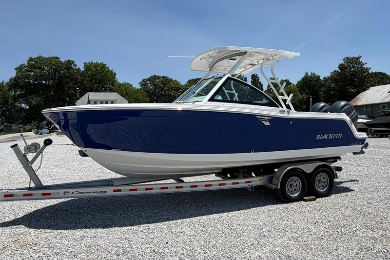 The Image of 2020 Blackfin 242 DC boat on trailer, blue hull, parked outdoors on gravel. - 0