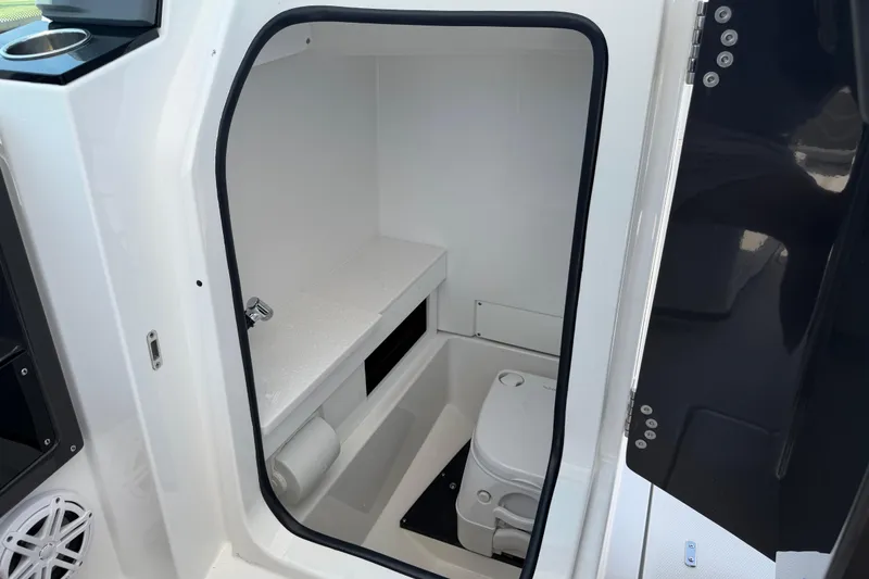 Slide: The Image of 2020 Blackfin 242 DC boat interior with compact marine toilet and storage space. - 32