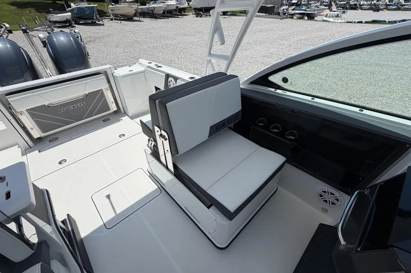 Slide: The Image of 2020 Blackfin 242 DC boat interior with seating and storage, parked in a marina. - 37