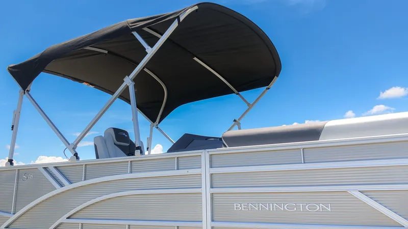 The Image of A Bennington 18 S CRUISE pontoon boat with a black canopy under a blue sky. - 1
