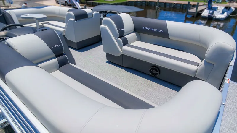 Slide: The Image of The image shows the spacious deck of a Bennington 18 S CRUISE pontoon boat with gray and blue seating. - 13