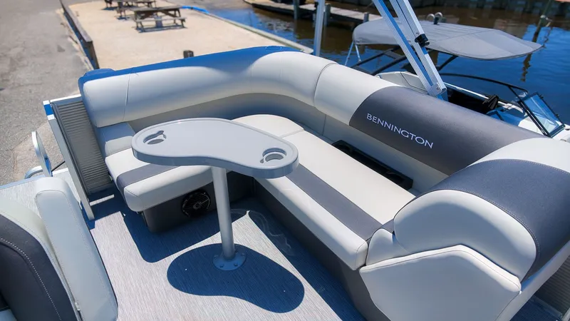 Slide: The Image of The image shows the sleek seating area of a 2027 Bennington 18 S CRUISE boat with a small table. - 6