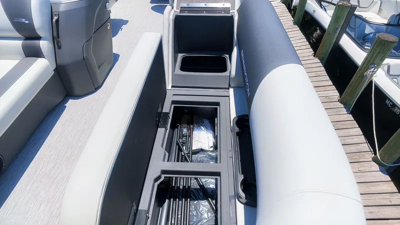 Slide: The Image of An open storage compartment on a Bennington 18 S CRUISE boat, containing fishing rods and accessories. - 12