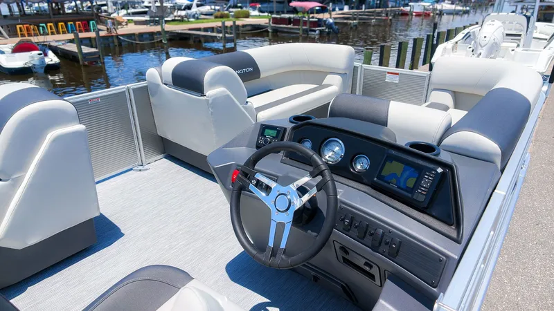 Slide: The Image of The image shows the cockpit of a Bennington 18 S CRUISE pontoon boat. It features a modern steering wheel and digital dashboard. - 16